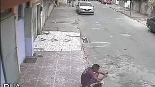 Perro orina a hombre sentado